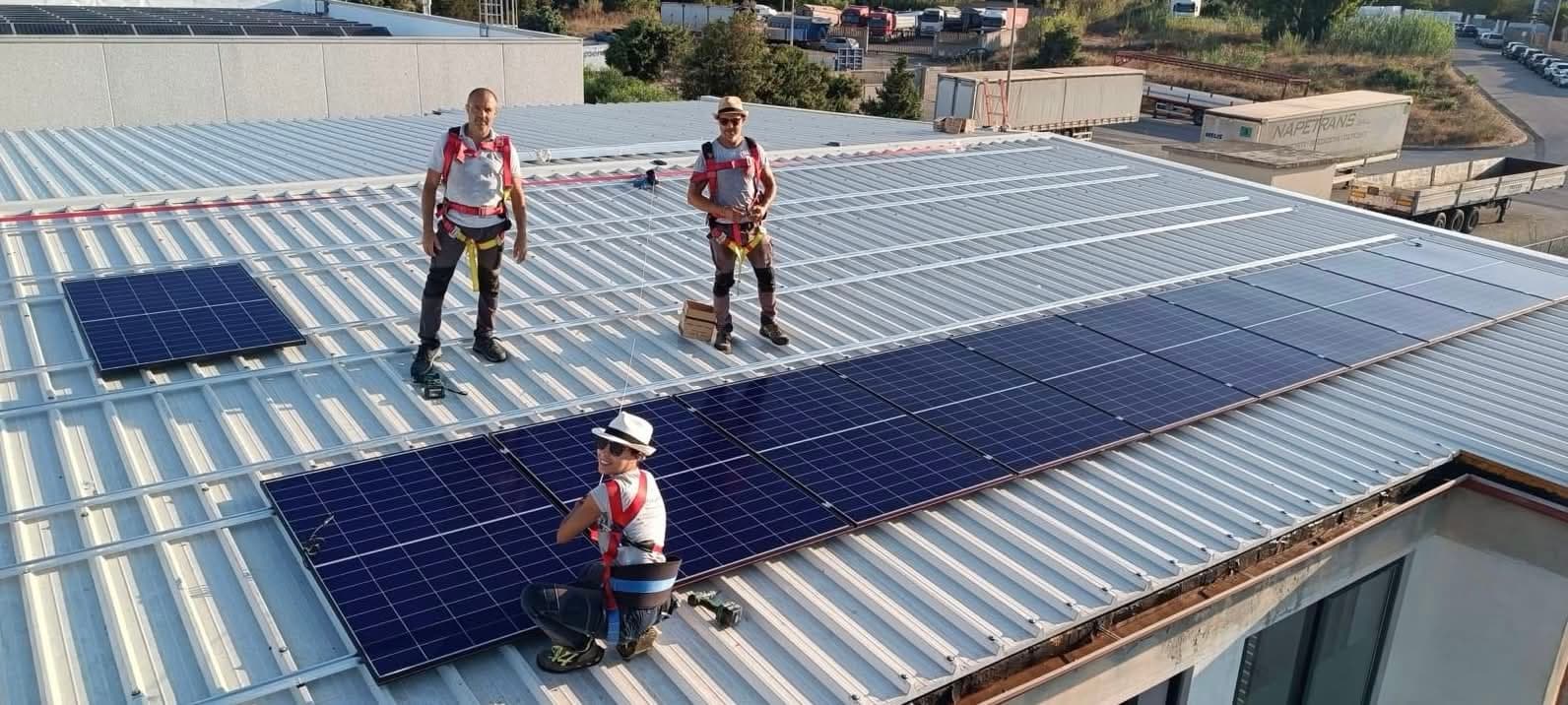 Tecnici Energy Sarda durante il montaggio di pannelli fotovoltaici sul tetto di un edificio in Sardegna